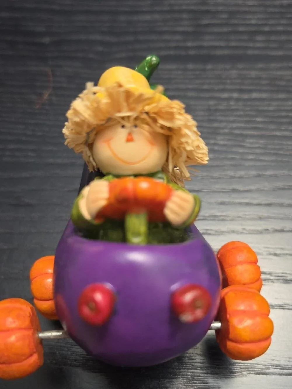 Autumn figurine of a scarecrow in a Eggplant cart